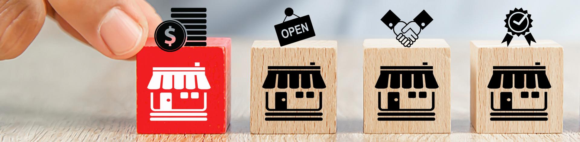 hand moving wooden blocks with business stores fronts in a line
