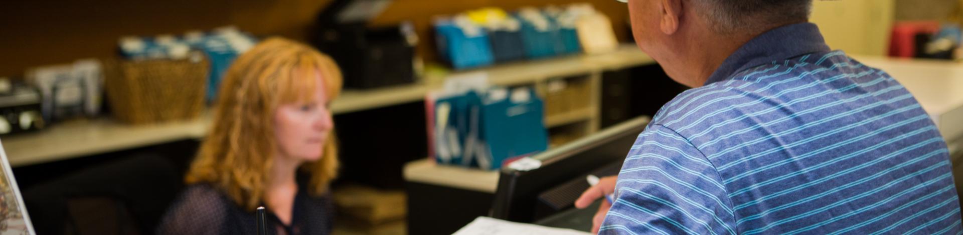 Resident being helped at front counter with customer service at municipal centre