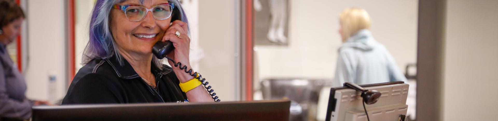 Recreation Staff on phone at client service desk