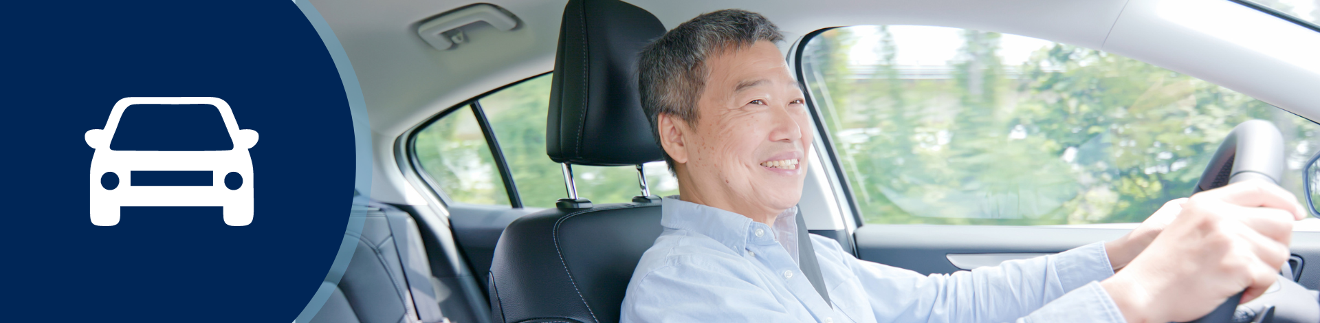 Middle aged man inside a vehicle with hands on the steering wheel