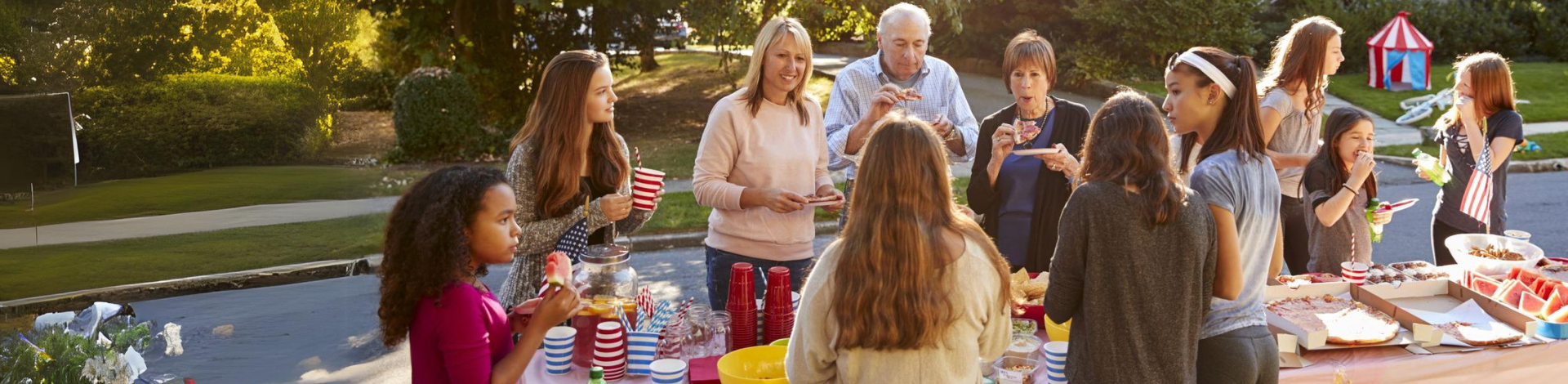 Neighbours gathering around a table with food