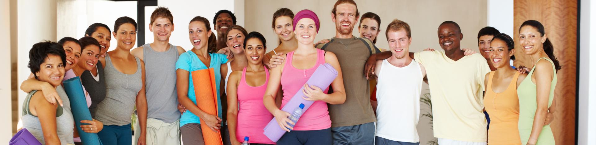group of people holding yoga mats