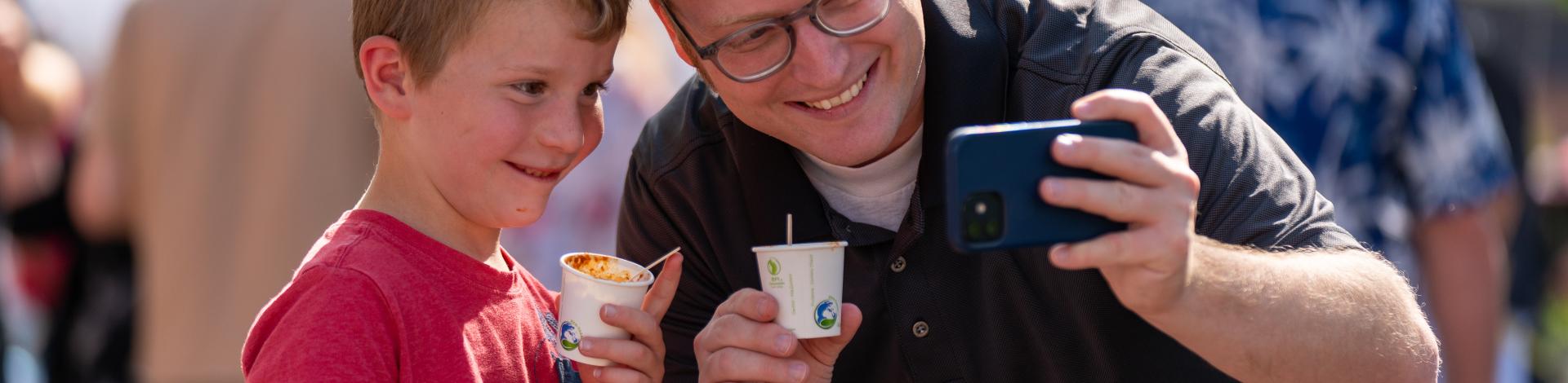 adult and child taking photo at chili fest 