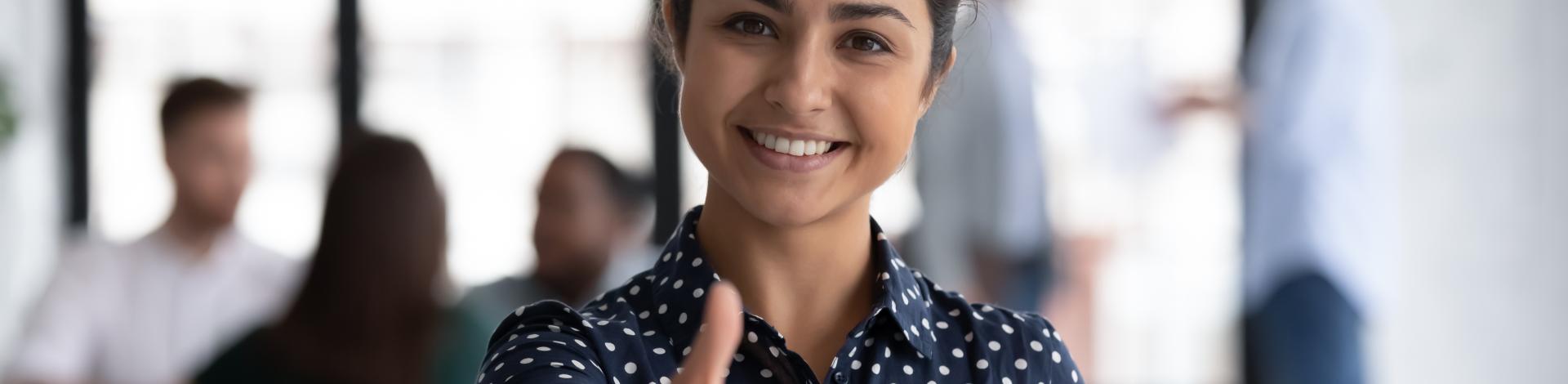 friendly woman stretching out hand to welcome someone to work in a recruitment job hiring setting