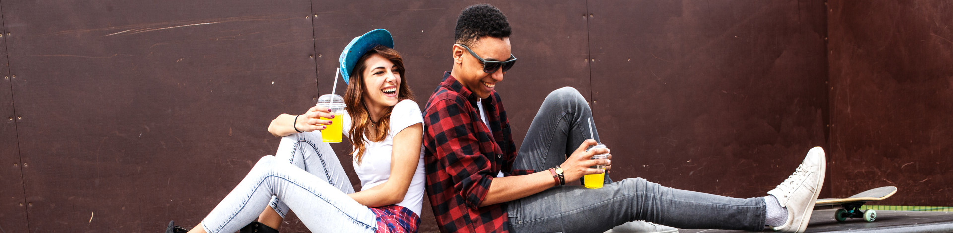 girl and boy sitting down at skate park