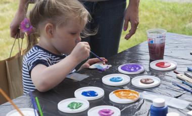 young child painting on picnic table 