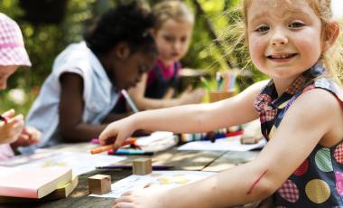Group of young children drawing outdoors