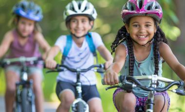 three happy kids riding bicycles