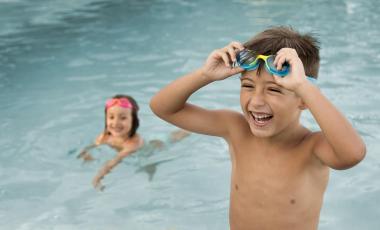 two kids smiling in pool