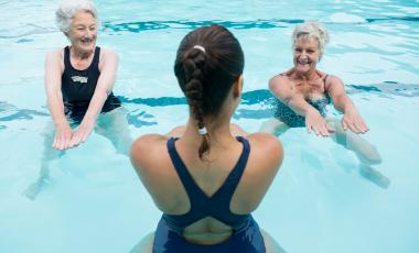 Smiling senior women exercising in swimming pool