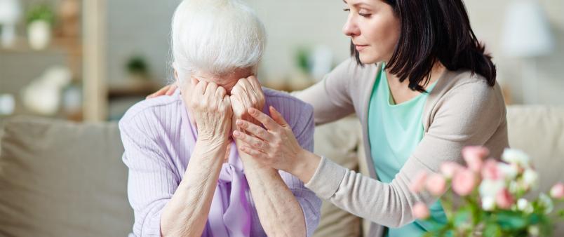 Daughter comforting senior mother
