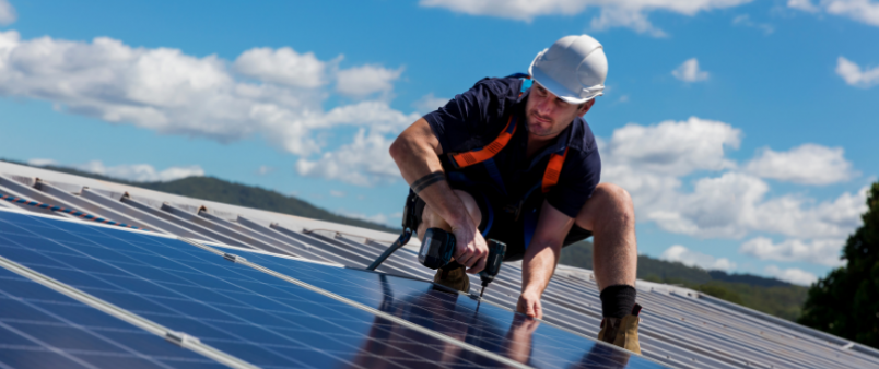 man on roof installing solar panels