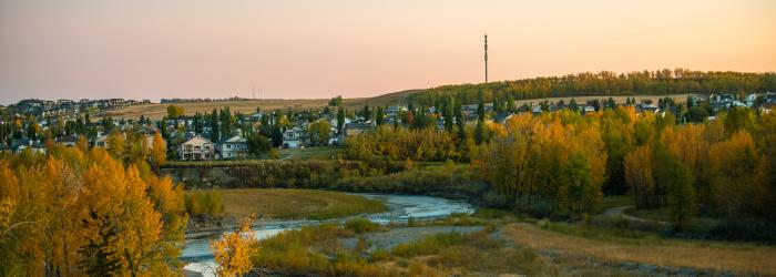 aerial view of Sheep River at dusk with houses in background