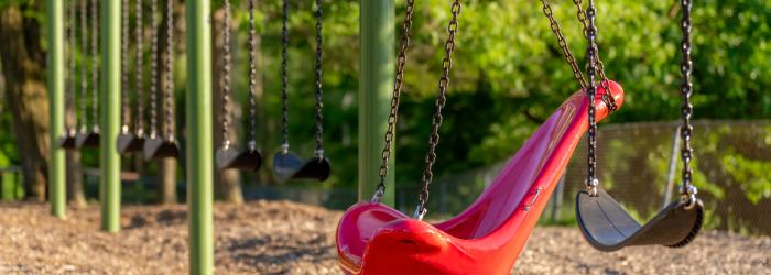 Red accessible swing on a swing set 