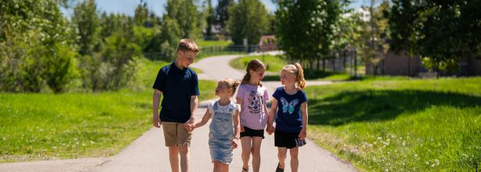 Children walking on pathway in green space