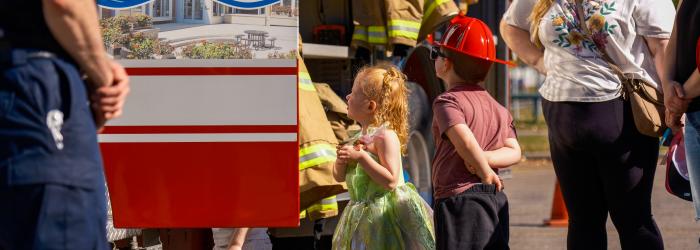 Young kids looking up at an Okotoks fire engine during Fire Prevention Week