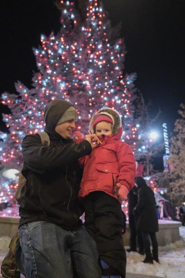 two people stand in front of a light tree