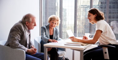 senior couple receiving advice from business woman in office building