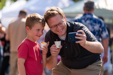 adult and child taking photo at chili fest 